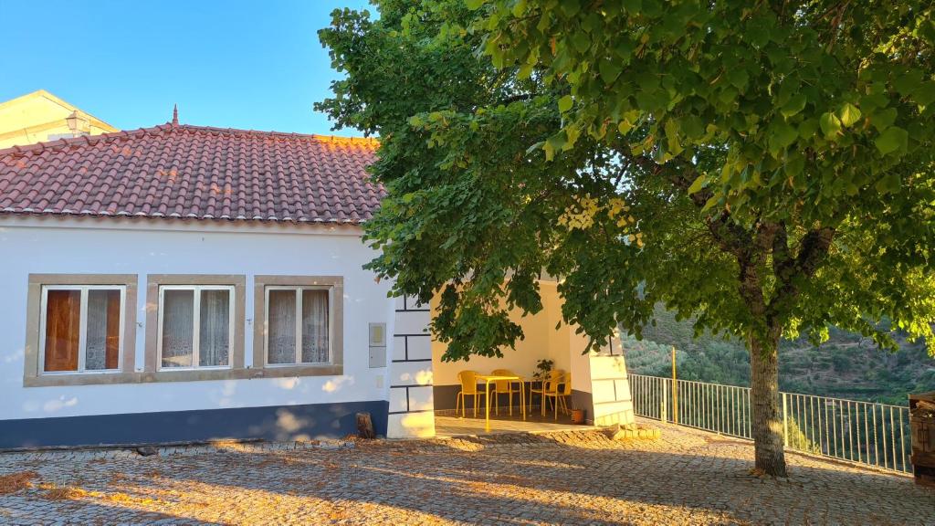 a white house with a tree in front of it at Casa das Tílias in Alvaro