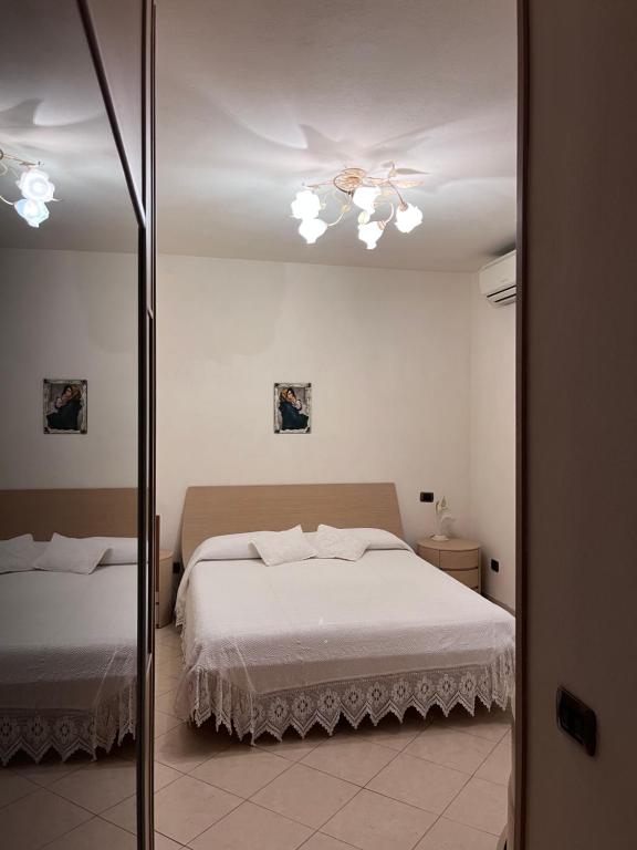 1 dormitorio con cama y espejo en La Casa di Margot en Forte dei Marmi