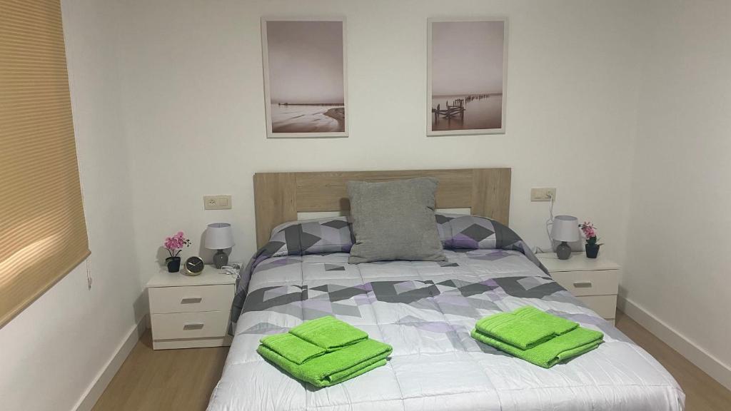 a bedroom with a bed with green towels on it at AMORE MÍO Hellín in Hellín