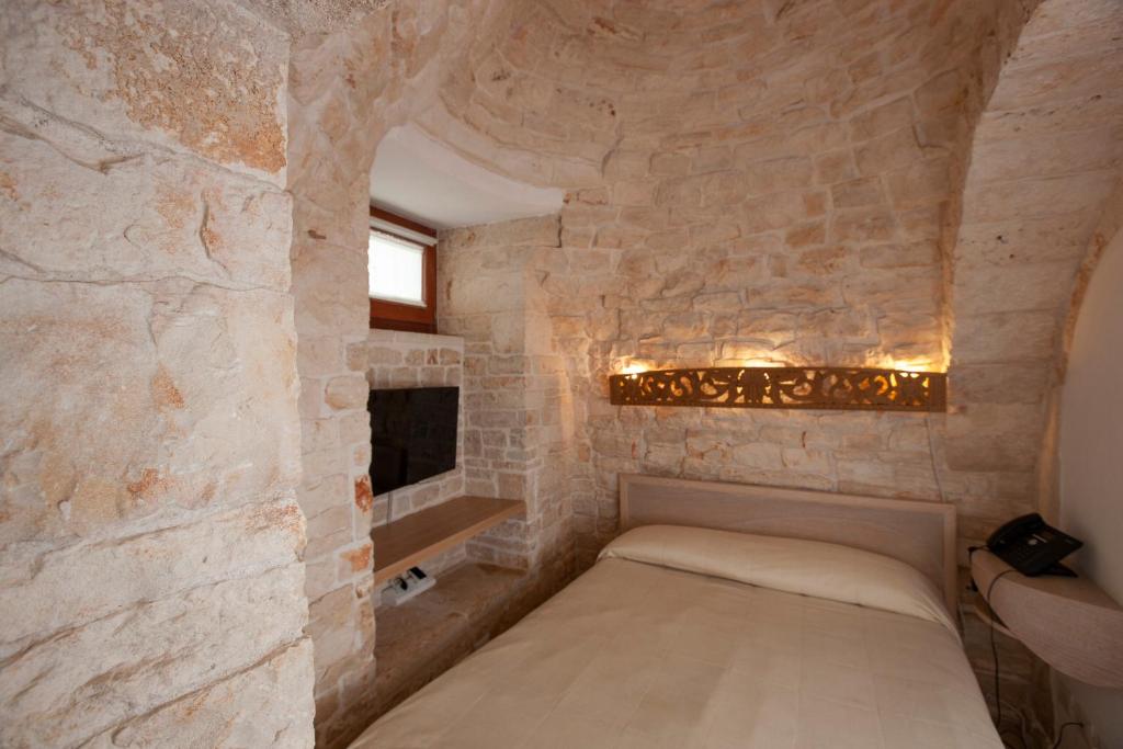 Postel nebo postele na pokoji v ubytování Le Alcove - Luxury Hotel nei Trulli