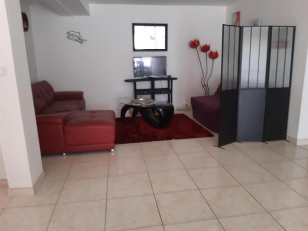 un salon avec un canapé rouge et une table dans l'établissement Le calme, à Viviers