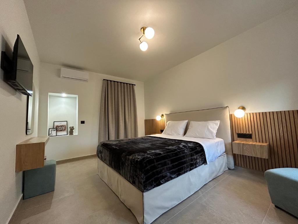 a hotel room with a bed and a television at Piedra Luxury Apartments in Nafplio