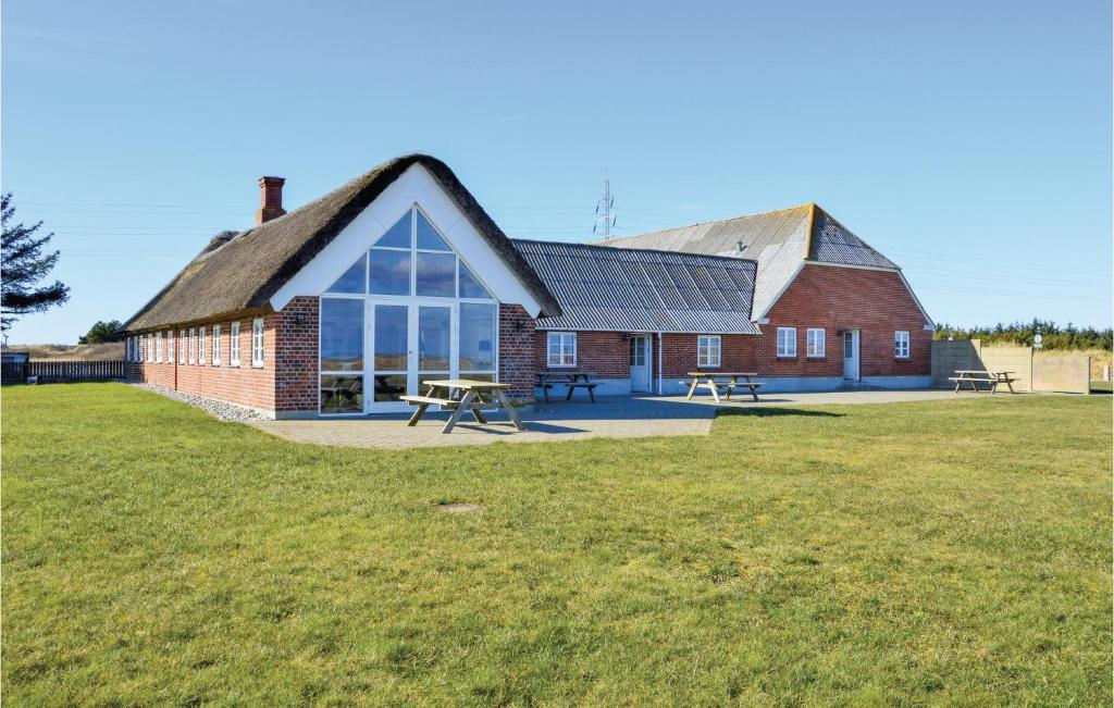 a red brick building with a large grass field at Lovely Home In Ringkøbing With Wifi in Klegod