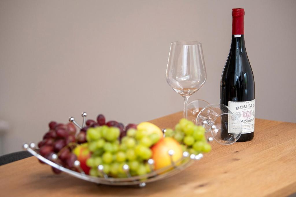 eine Schale Obst und eine Flasche Wein auf dem Tisch in der Unterkunft Villa Kaliva in Bullay