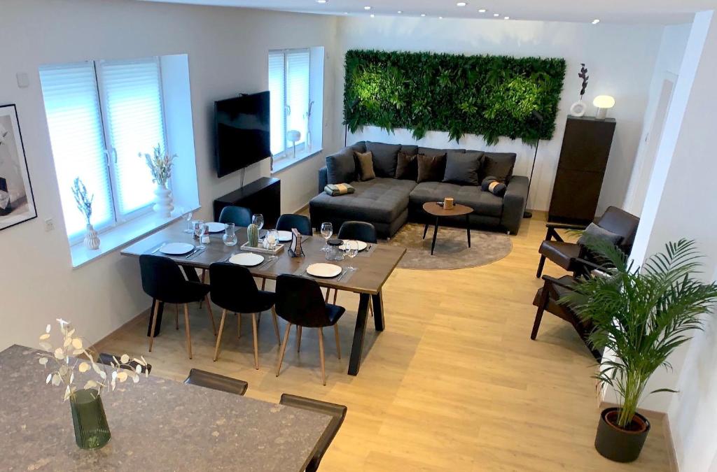 sala de estar con sofá, mesa y sillas en Luxuriöses 65 qm Apartment »B28« für 2+2 Gäste, en Chemnitz
