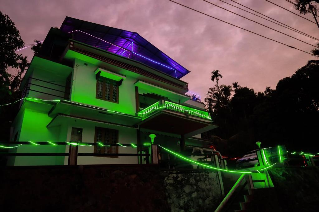 - un bâtiment avec des lumières vertes et violettes dans l'établissement kaffee valley homestay, à Padinjarathara