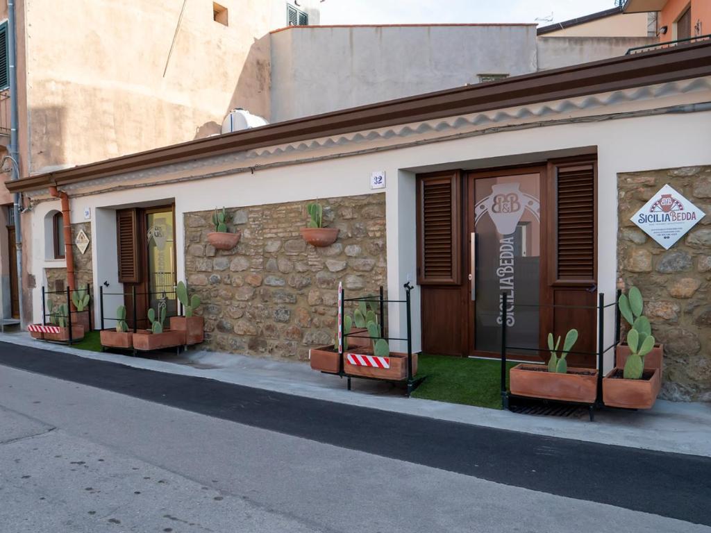 un edificio con macetas al costado. en Sicilia Bedda - B&B - Rooms - Apartments, en Santo Stefano di Camastra
