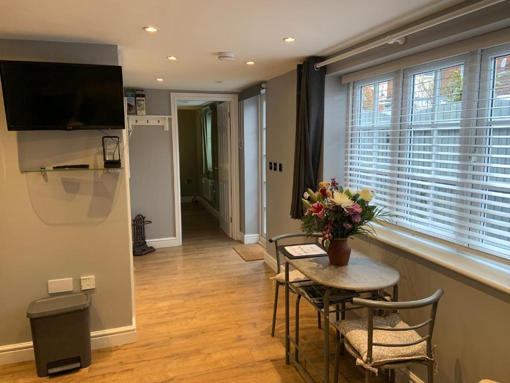 a living room with a table and chairs and a television at Scott’s lodge in Kent