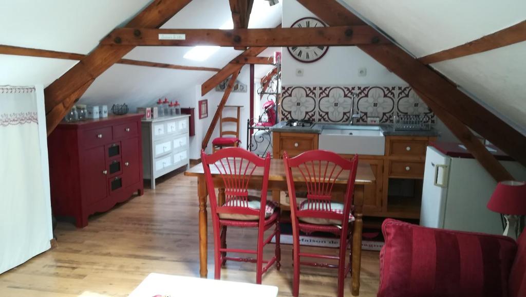 une cuisine avec des chaises rouges et une table en bois dans l'établissement La tiote glaine, à Cappelle-en-Pévèle