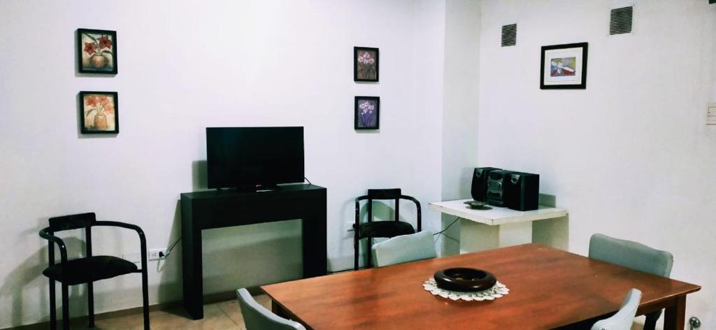 a living room with a wooden table and a television at departamento centrico de un dormitorio para tres personas in San Juan