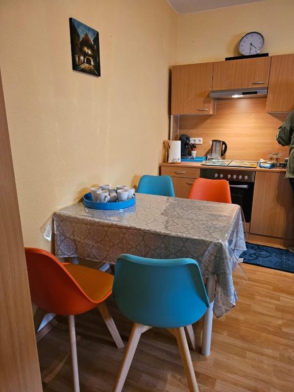 a kitchen with a table and four chairs at Eigener Eingang, 1-Zimmer mit Bett und große Wohnküche mit Schlafcouch in Oberhausen