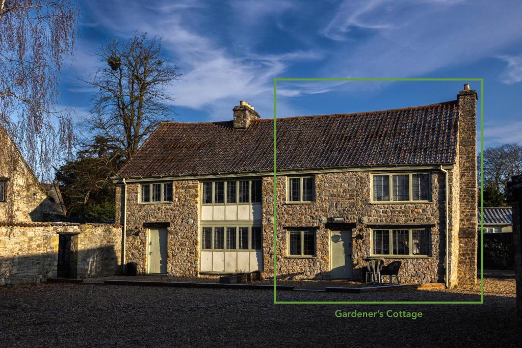 uma grande casa de pedra com uma linha verde à sua volta em Gardener's Cottage em Chepstow