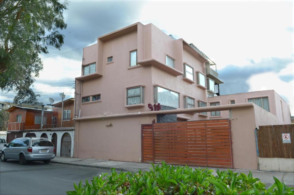 una casa rosa con un coche aparcado delante de ella en 914 Hotel, en Calama