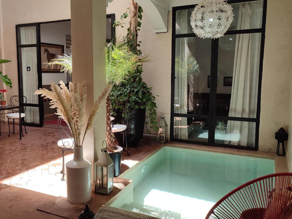 a hot tub in a living room with plants at RIAD PÉNÉLOPE Marrakech in Marrakesh