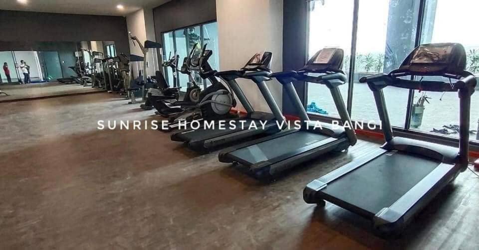 een fitnessruimte met loopbanden en crosstrainers in een sportschool bij Sunrise Homestay Vista Bangi in Kajang