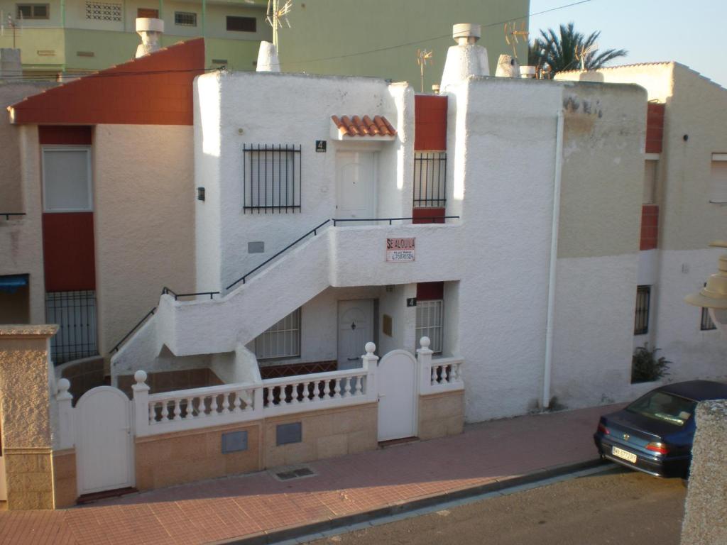 un edificio blanco con una escalera lateral en Apartamento Las Gaviotas en Cabo de Gata