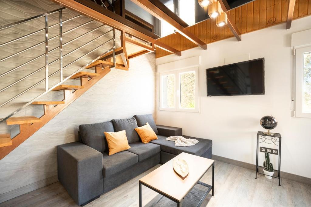 ein Wohnzimmer mit einem Sofa und einer Treppe in der Unterkunft Suites Bola de Oro in Granada