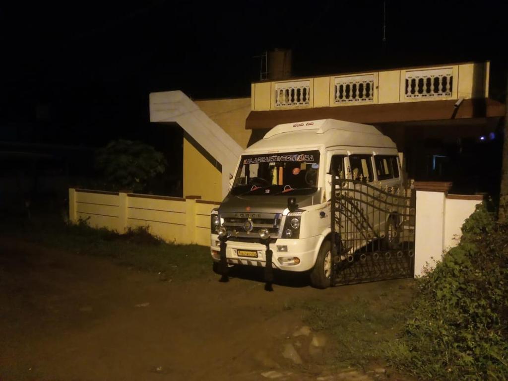 una furgoneta blanca estacionada frente a un edificio por la noche en Coorg Get Inn Home Stay, en Madikeri