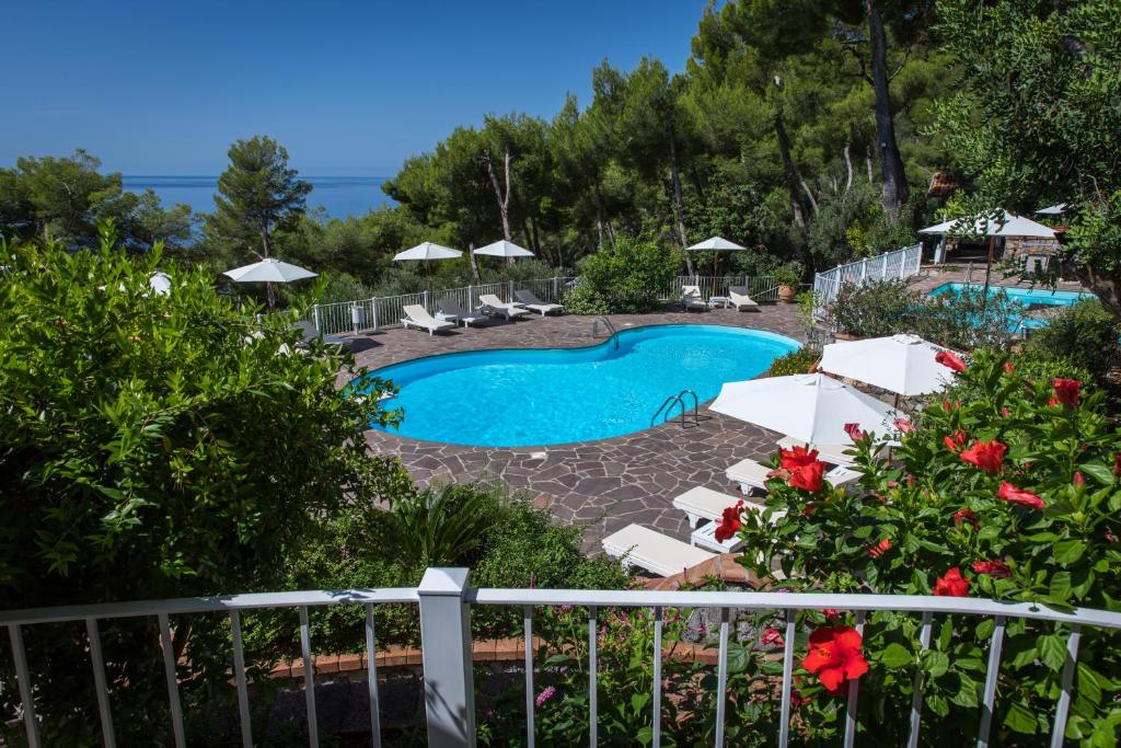 vista su una piscina con sedie e ombrelloni di Hotel Villa Delle Meraviglie a Maratea