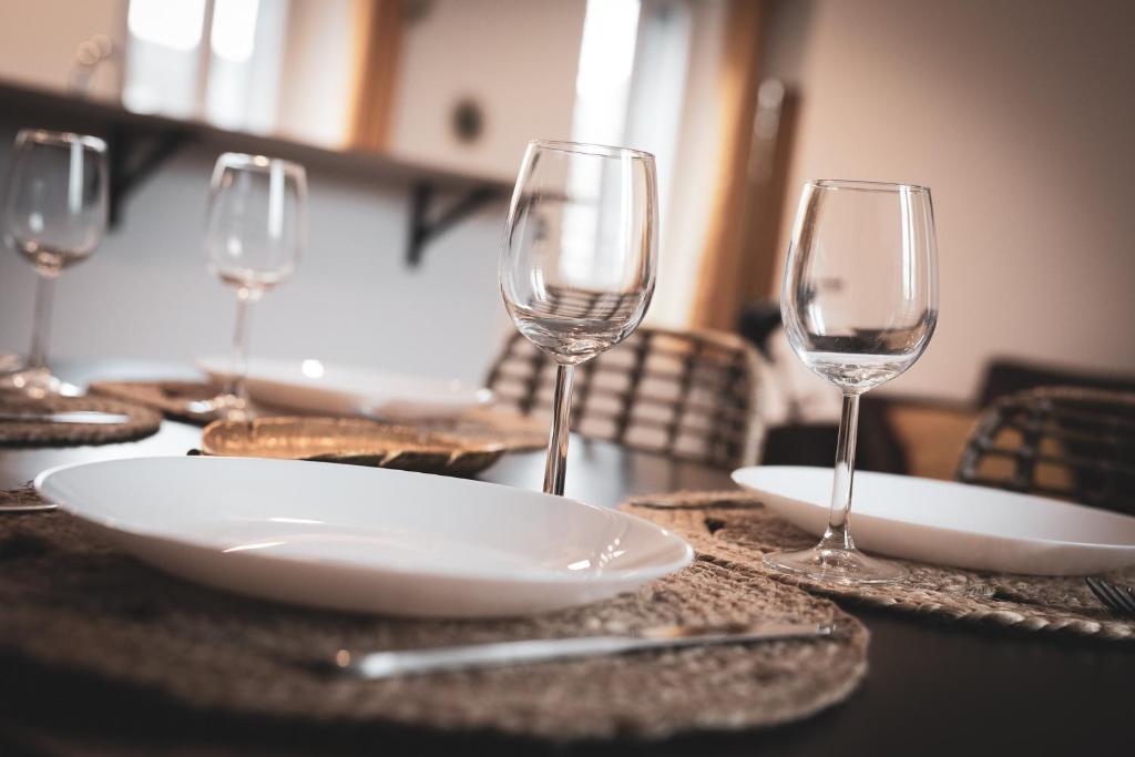 une table recouverte de assiettes blanches et de verres à vin dans l'établissement Escapade Eudoise, à Eu