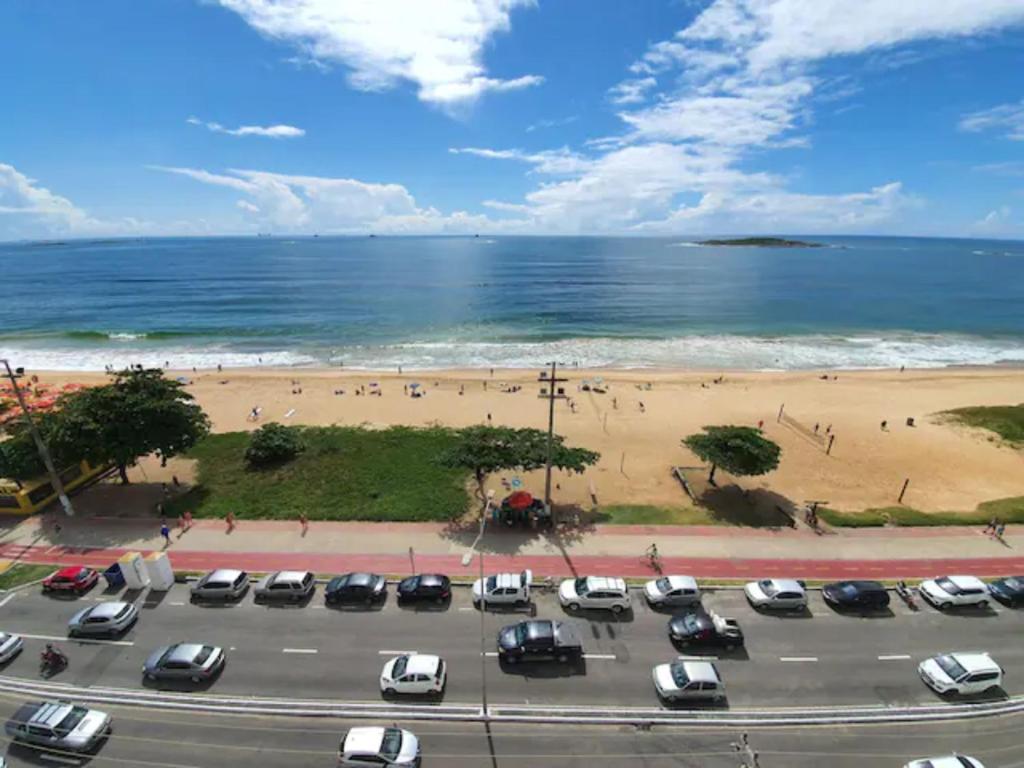 - un parking à côté d'une plage avec des voitures dans l'établissement Apartamento Completo Frente Praia de Itaparica, à Vila Velha