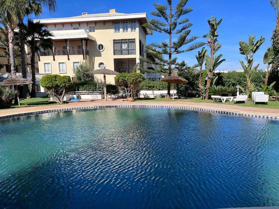 a large swimming pool in front of a building at Appartement Bouznika Bay Golf in Bouznika