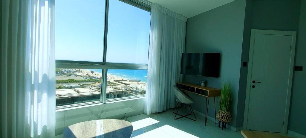 a room with a large window and a television at beach front tel aviv bat yam apartment -hotel 39 in Bat Yam