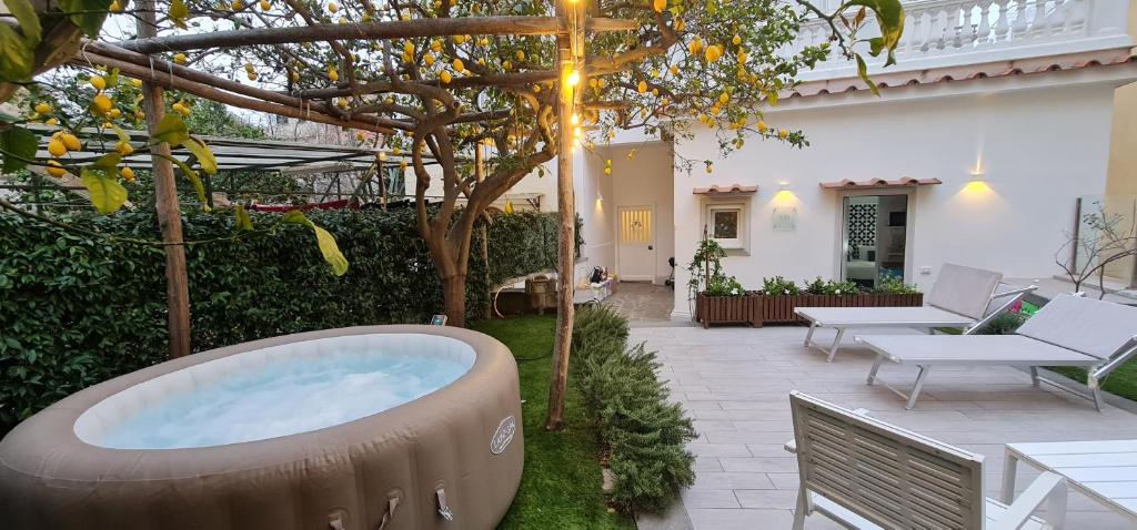 een achtertuin met een hot tub in de tuin bij MARILISE - La maison bleue private hot tube, garden & terrace in Meta