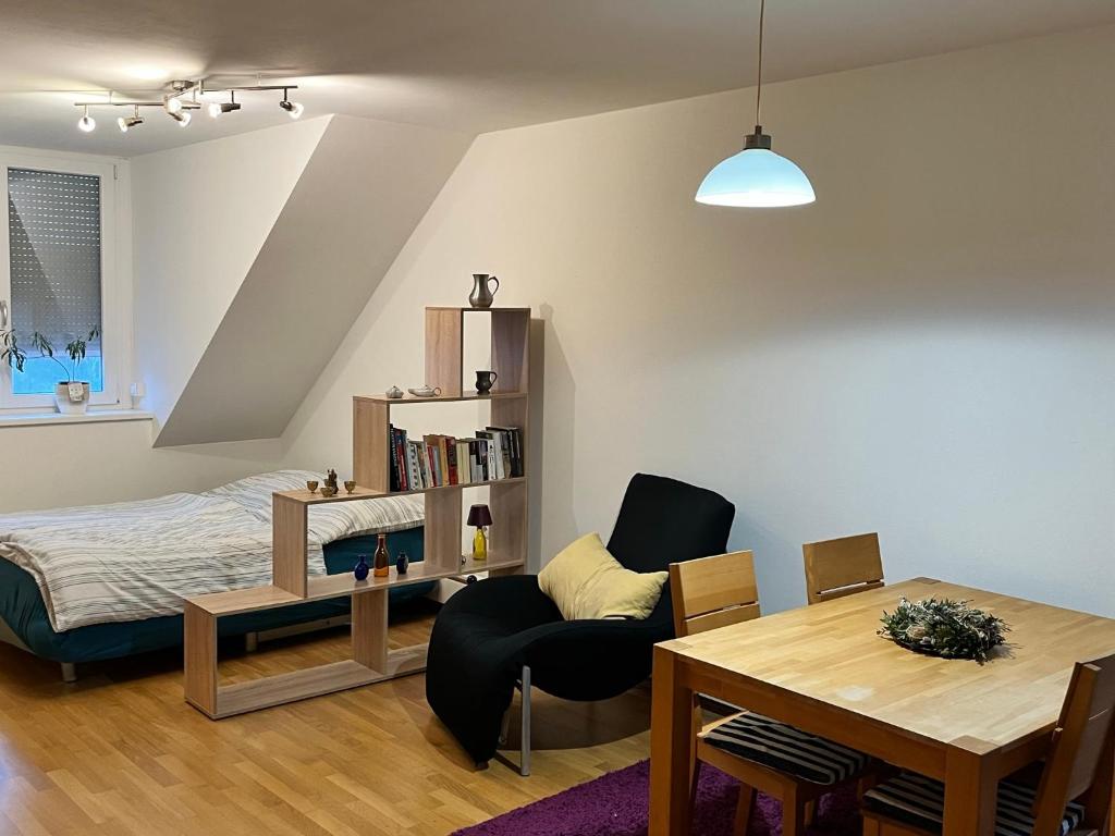 een slaapkamer met een bed, een tafel en een stoel bij Charmantes Appartement - München in München