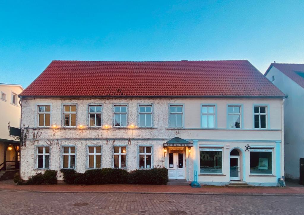 un grand bâtiment blanc avec un toit rouge dans l'établissement Spurensucher Quartier, à Usedom Town