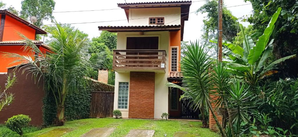 a house with a balcony on the side of it at Casa dos Coqueiros Praia de Camburi, condomínio in Camburi