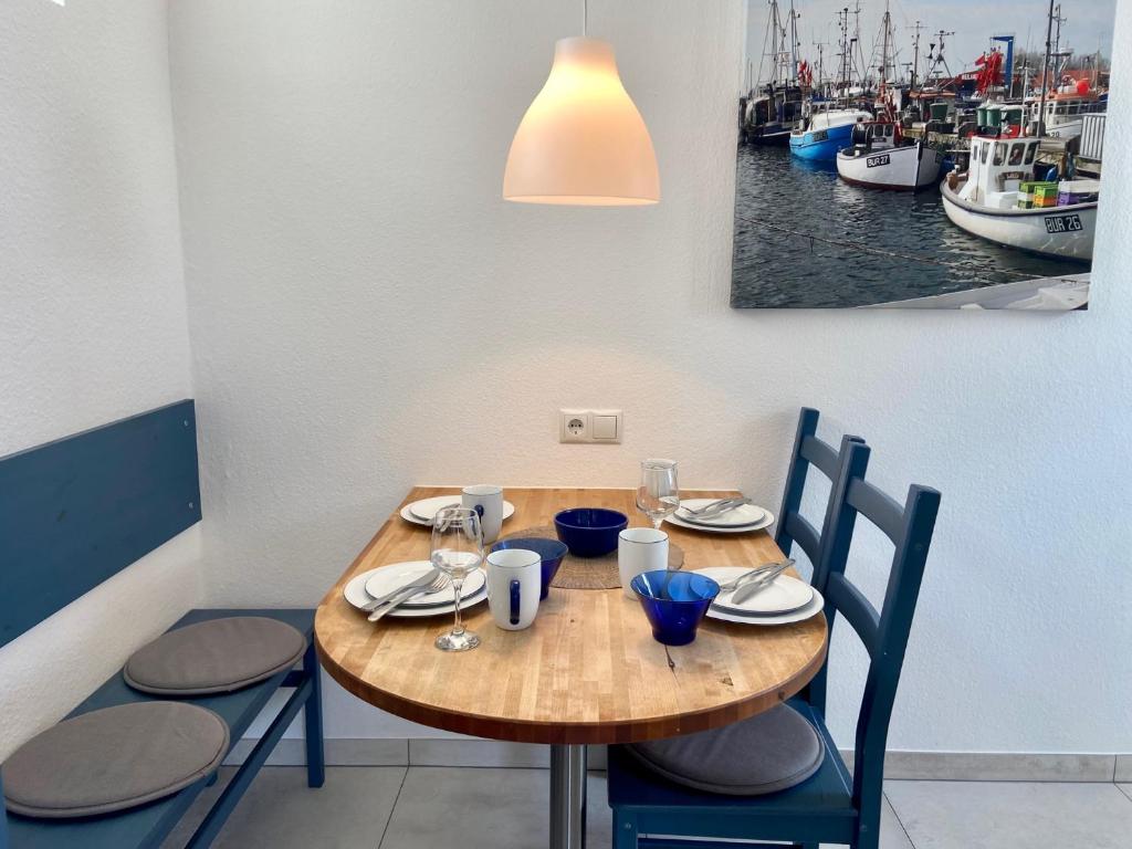 einen Holztisch und Stühle mit Booten im Wasser in der Unterkunft 1008 - Bungalow Ziegenbalg in Dahme