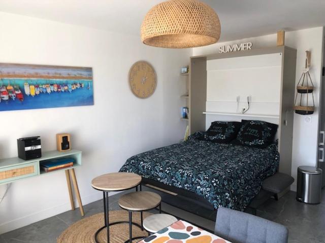 a bedroom with a bed and a table and stools at Appartement cosy à Boyardville in Boyard-Ville