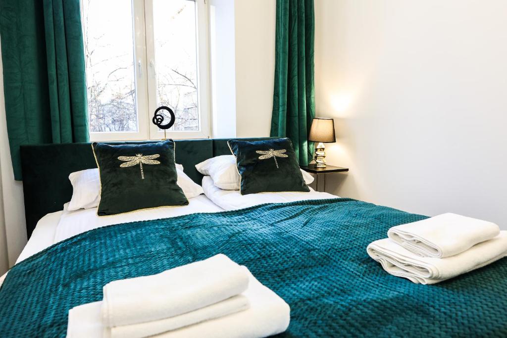 1 dormitorio con 1 cama con toallas en CracWoW Saint Sebastian Apartments, en Cracovia
