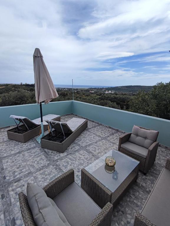 a patio with furniture and an umbrella on a roof at Anatolika Stamatis Paradise in Dhémbla