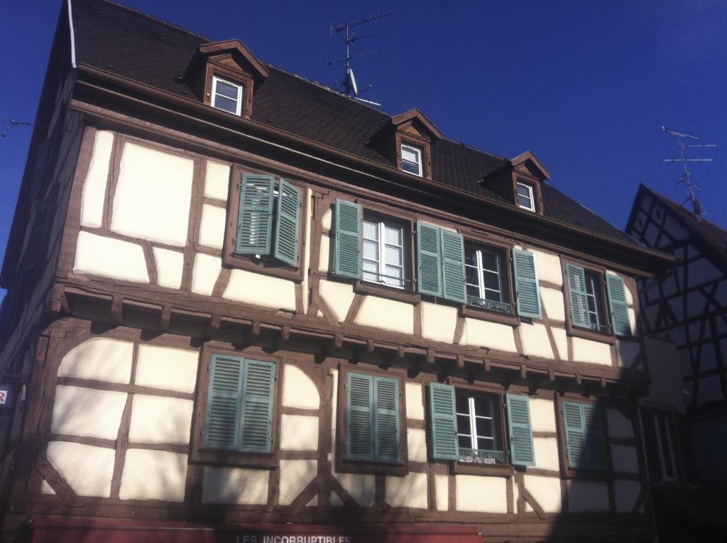 Un vieux bâtiment avec des volets verts dans l'établissement Gite l'Ame d'Antan, à Colmar
