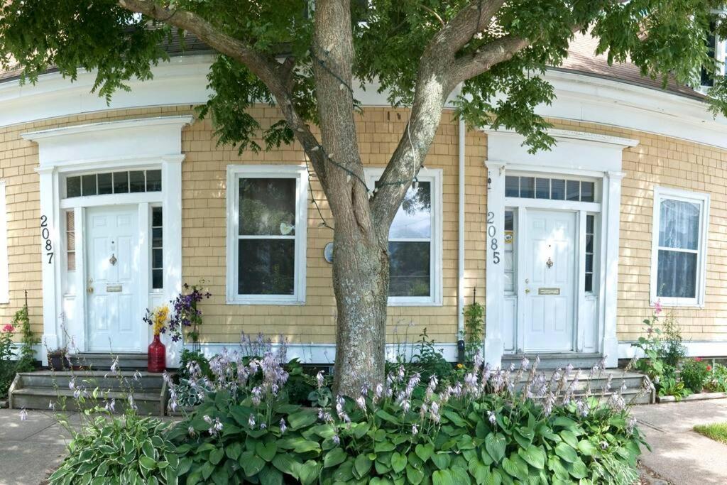 a house with a tree and flowers in front of it at Heritage Townhouse in Downtown Halifax in Halifax