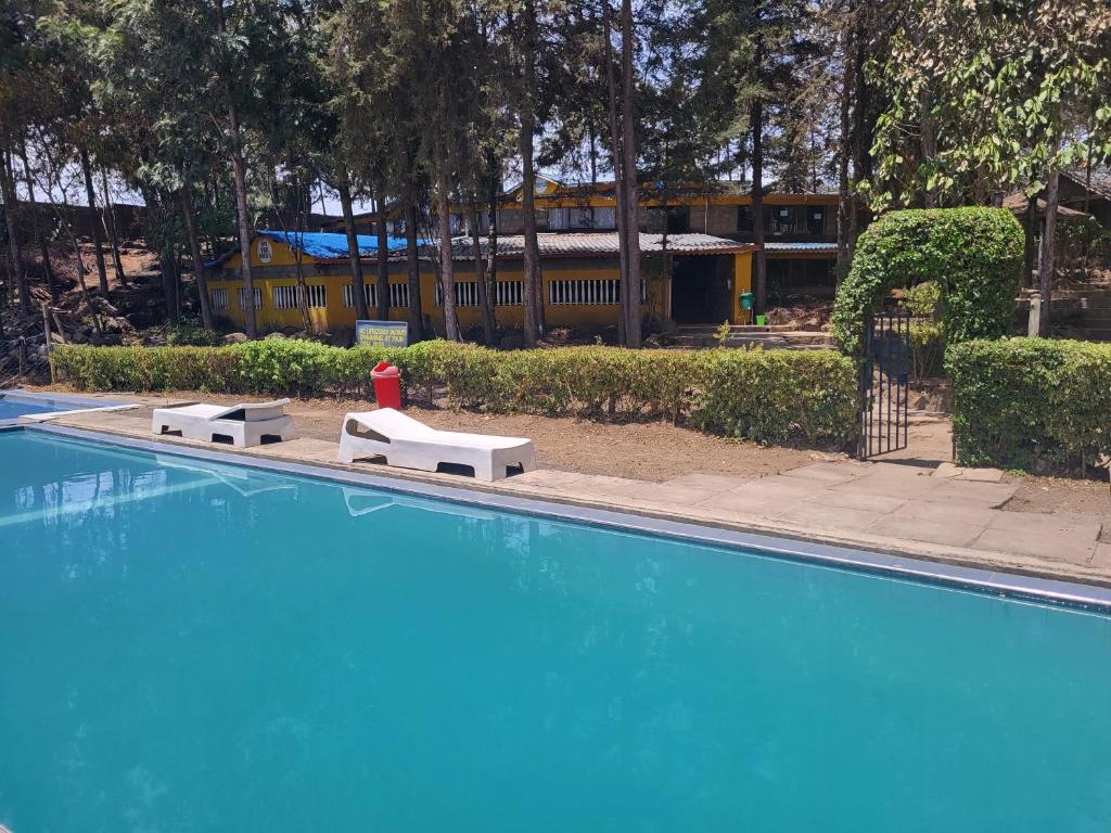 a blue swimming pool with a red fire hydrant next to it at Triple Eden Resort - Naivasha in Naivasha
