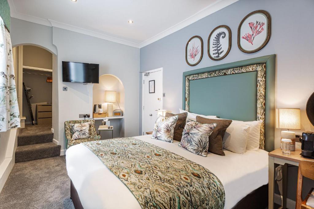 a bedroom with a large bed with pillows at The Manor Coastal Hotel & Inn, Blakeney - part of The Coaching Inn Group in Blakeney
