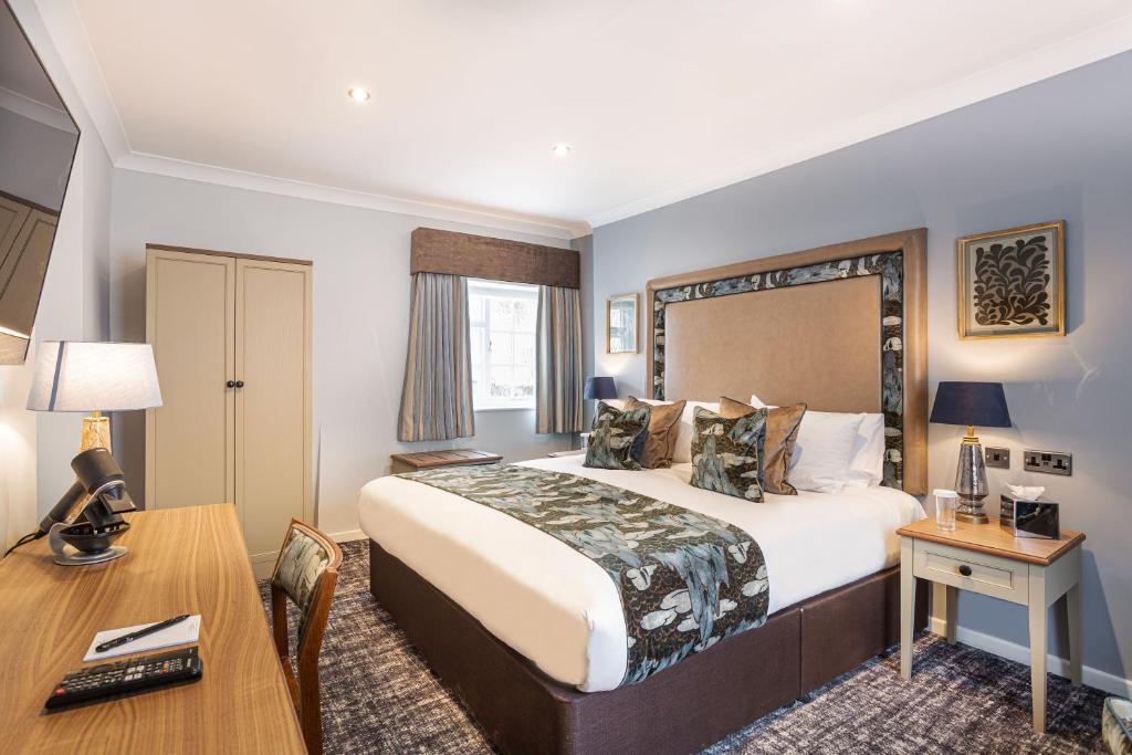 a hotel room with a bed and a desk at The Manor Coastal Hotel & Inn, Blakeney - part of The Coaching Inn Group in Blakeney