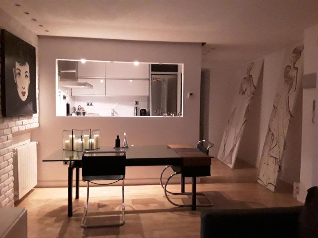 una sala da pranzo con tavolo e una cucina di Loft luminoso y céntrico a Saragozza