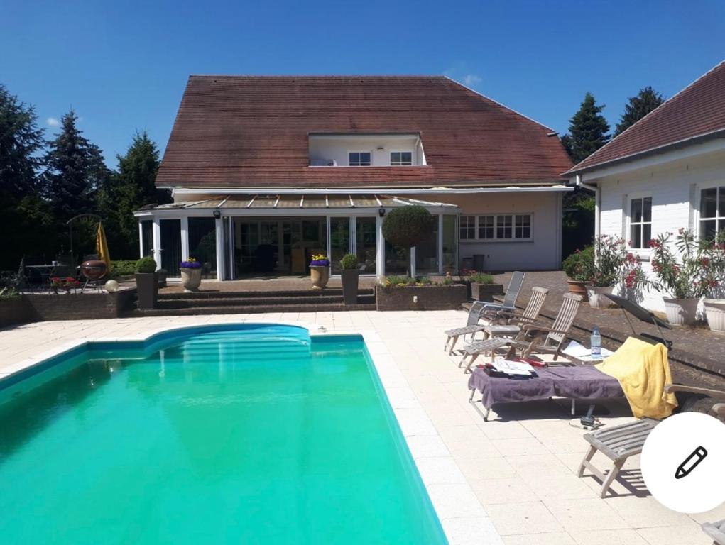 una piscina di fronte a una casa di Villa Haagdoorn te Achel, 10 personen, 12 personen op aanvraag, met zwembad op het zuiden in een oase van rust! ad Achel