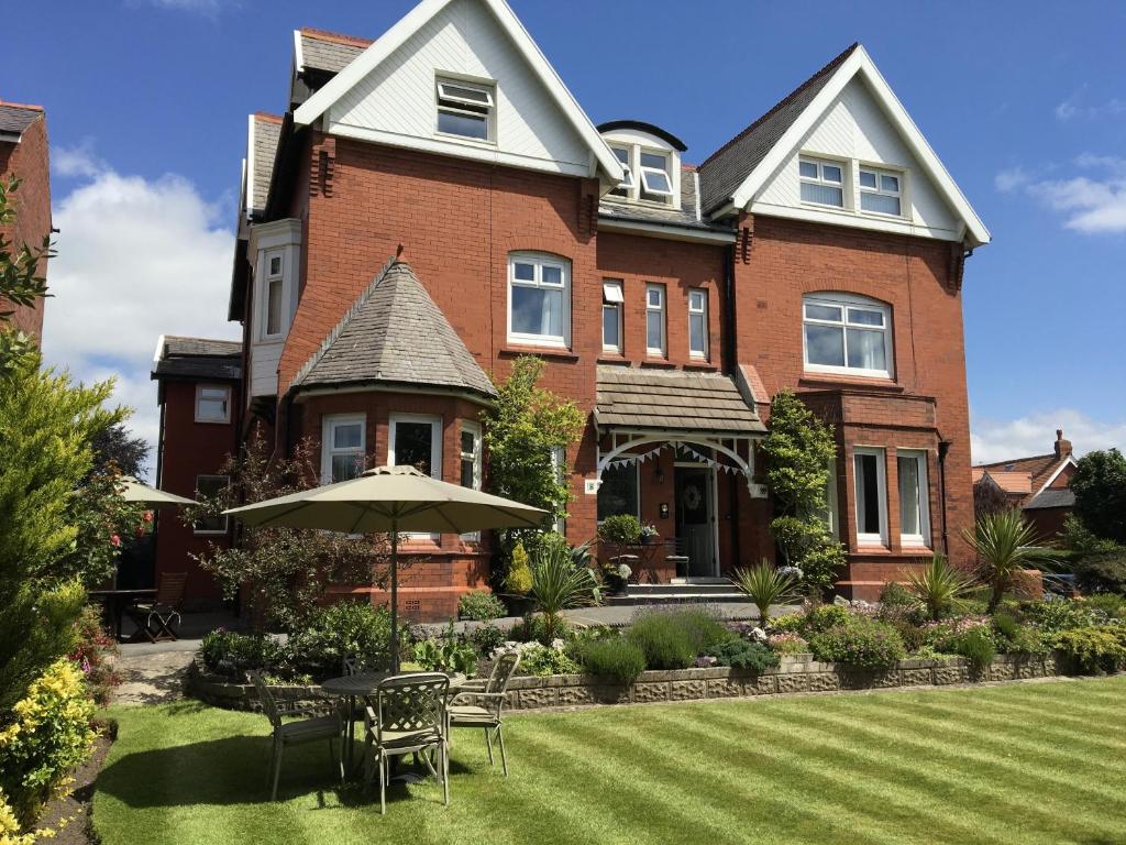 a large brick house with an umbrella in the yard at The Old School House in Lytham St Annes