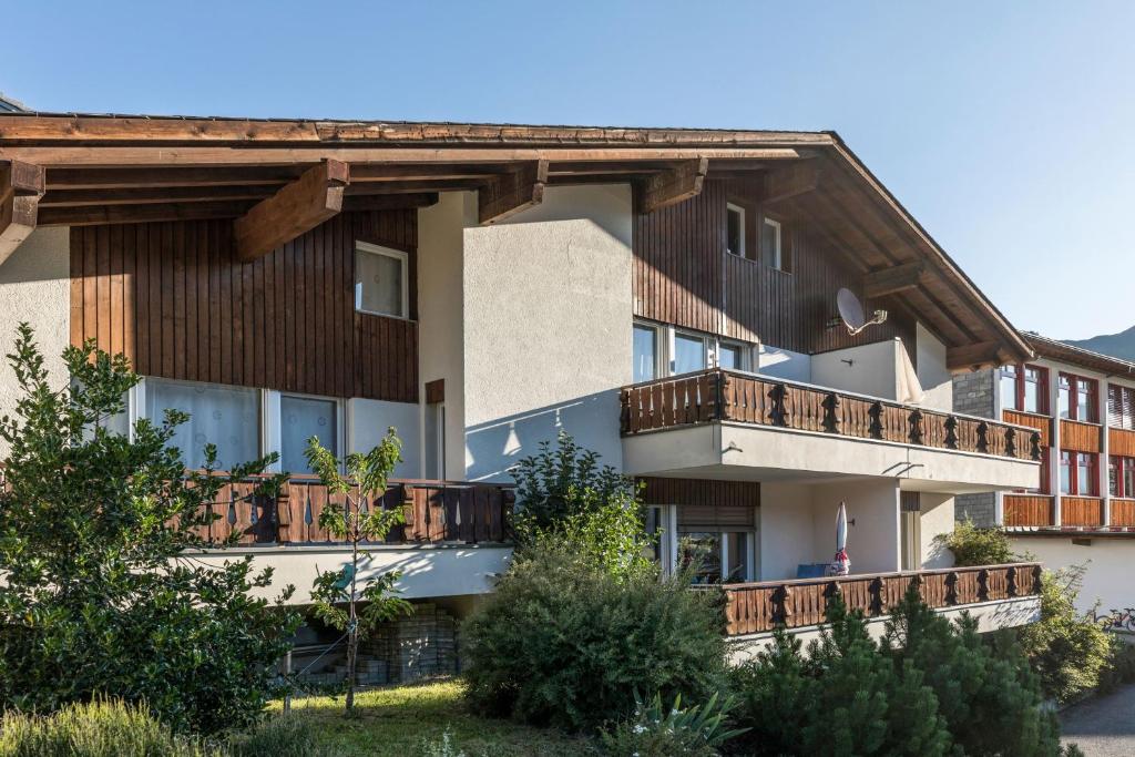 ein großes Gebäude mit Holzbalkonen darauf in der Unterkunft Casa LA RODA in Sedrun