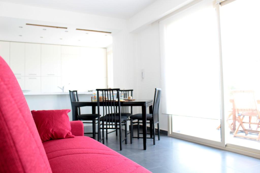 a living room with a pink couch and a table at The Green Seaside in Fondachello