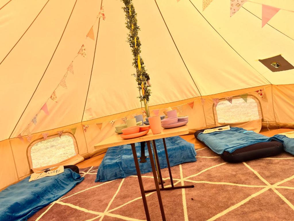 a tent with a table in the middle of it at Dollys Den bell tent in St. Just
