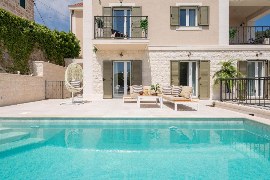 a swimming pool in front of a house at Villa Mirta in Bol