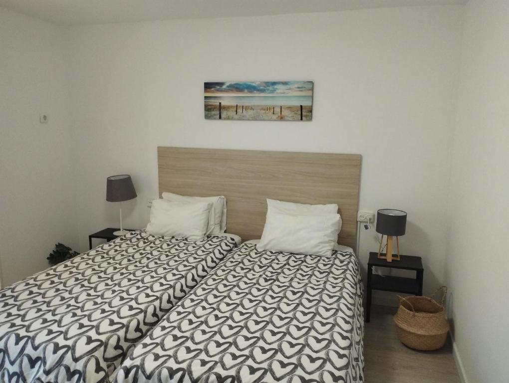 a bedroom with a bed with a black and white comforter at Day Ok Casa Terrasa Beach in Malgrat de Mar