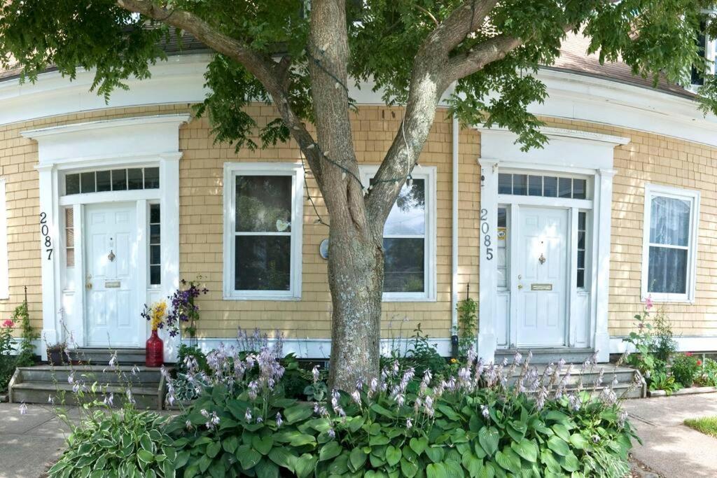 una casa con un árbol y flores delante de ella en Heritage Row House in Downtown Halifax en Halifax