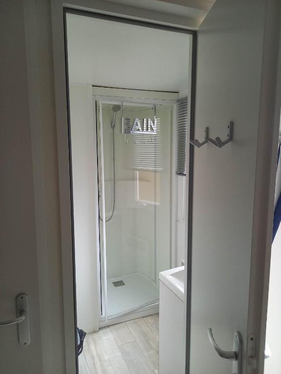 prysznic w łazience ze szklanymi drzwiami w obiekcie Mobilhome 6 pers avec Clim w mieście Saint-Georges-de-Didonne